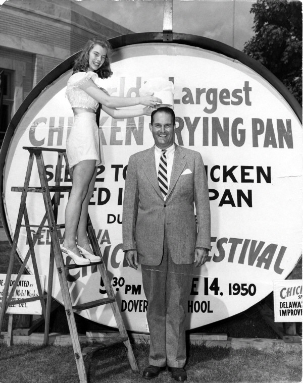 Governor Elbert Carvel and Delmarva Chicken Festival Queen Jane Mustard flash their smiles as she pretends to place a chef’s hat on the Governor’s head at the 1950 Delmarva Chicken Festival.