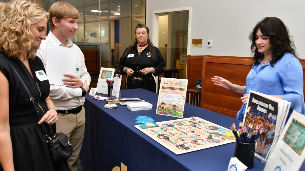 Delaware Public Archives staff member Maria Myer showcases the Archives’ new board game, Road to Liberty.