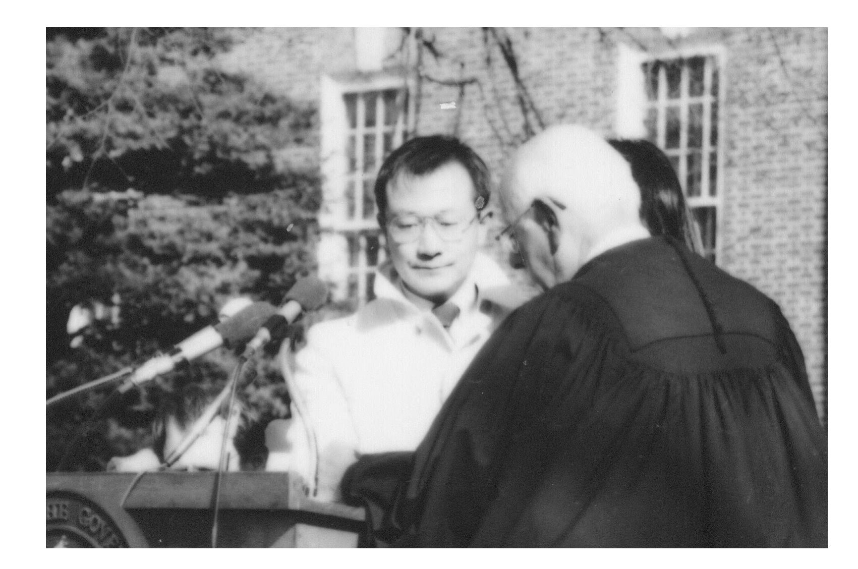 S. B. Woo taking his oath of office with Chief Justice Daniel Herrmann at a podium.