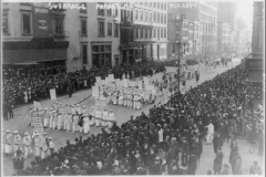 Forty thousand march in a NYC suffrage parade. Many women are dressed in white and carry placards with the names of the states they represent