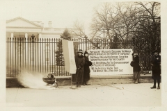 The National Women’s Party watches as a fire burns outside of the White House in January 1919.