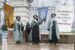 Women suffragist holding banners in the rain